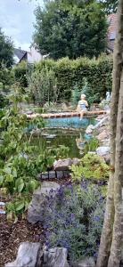 a woman sitting in a swimming pool in a garden at Ferienwohnung Anke Günther Dach in Bad Kissingen