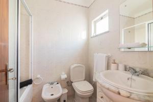 a white bathroom with a toilet and a sink at Casa Do Sol - Estombar Algarve in Estômbar +13 photos