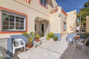 a house with a patio with chairs and plants at Casa Do Sol - Estombar Algarve in Estômbar