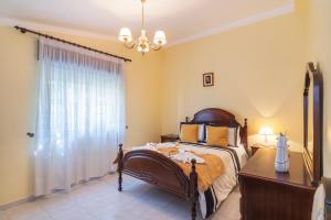 a bedroom with a bed and a dresser and a window at Casa Do Sol - Estombar Algarve in Estômbar