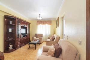 a living room with a couch and chairs and a tv at Casa Do Sol - Estombar Algarve in Estômbar