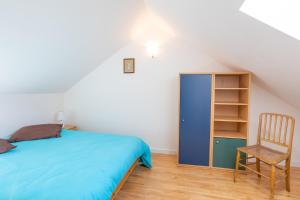 a bedroom with a bed and a chair and a book shelf at Au Fil Du Réguinier - Gîte Briançon in Briançon