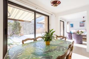 a dining room with a table with a plant on it at Au Fil Du Réguinier - Gîte Briançon in Briançon