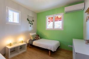 a small bedroom with a bed and two windows at Chambre - Dorine in Aroue