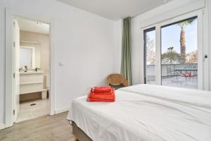 a white bedroom with a bed and a large window at Apartamento Playa Cabria in Almuñécar +24 photos