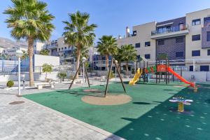 an empty playground with a slide and swings at Apartamento Playa Cabria in Almuñécar