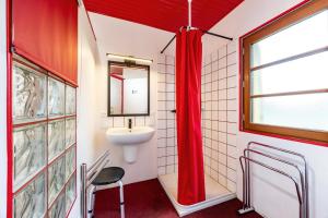 a bathroom with a sink and a red shower curtain at Gite de l'Ecluse in Bassanne +20 photos