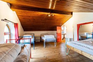 a bedroom with two beds and a wooden ceiling at Gite de l'Ecluse in Bassanne