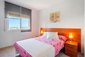 a bedroom with a bed and a window with a beach at Casa Anglada in Calafell +25 photos