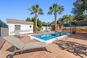 a swimming pool in a backyard with palm trees at Casa Anglada in Calafell