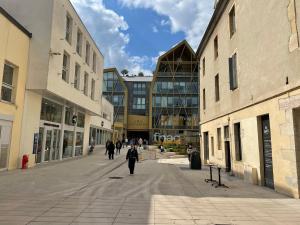 a man walking down a street in front of buildings at Hyper centre, rue piétonne, calme in Dijon