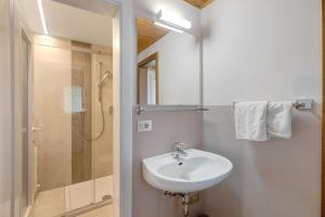 a white bathroom with a sink and a shower at Harmony Apt 1 in Appiano sulla Strada del Vino