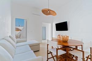 a living room with a white couch and a table at Dimora delle Riserve Naturali in Torre Colimena