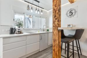 a kitchen with white cabinets and a bar stool at Chabelas Loft in Lajita