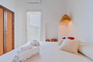 a bedroom with a white bed with towels on it at Dimora delle Riserve Naturali in Torre Colimena