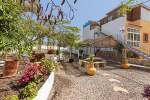a courtyard with vases and a bench and plants at Chabelas Loft in Lajita