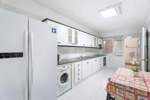 a kitchen with white cabinets and a washing machine at Casa Francisco in Granadilla de Abona