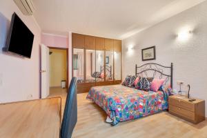 a bedroom with a bed and a flat screen tv at Casa Francisco in Granadilla de Abona