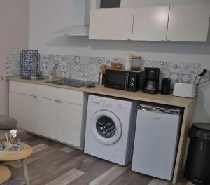 a kitchen with a washing machine and a microwave at App de caractère Centre Joigny Z1 in Joigny