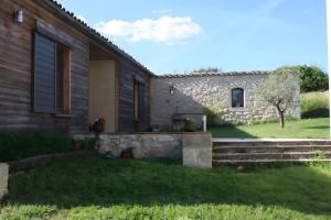 a house with a stone wall and a yard at Ferme De Berteillé in Castérat-Bouzet