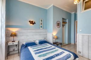 a bedroom with blue walls and a large bed at Chambre d'hôtes - Le quartier haut in Sète