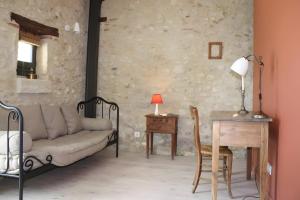 a living room with a couch and a table and a desk at Ferme De Berteillé in Castérat-Bouzet