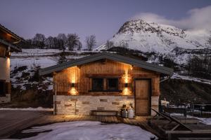 a cabin with a snow covered mountain in the background at Chalet D'albiez in Albiez-Montrond