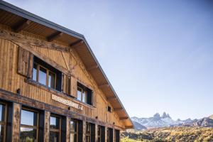 a wooden building with mountains in the background at Chalet D'albiez in Albiez-Montrond