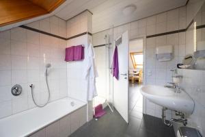 a bathroom with a tub and a sink and a shower at Ferienwohnung Mara in Öhningen +22 photos