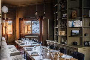 a dining room with tables and chairs and a book shelf at Chalet D'albiez in Albiez-Montrond