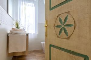 a bathroom with a door with a plant on it at Villa Agnese 2- Penthouse- Seaview in Badesi +29 photos