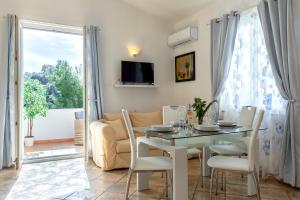a dining room with a table and chairs and a window at Villa Agnese 2- Penthouse- Seaview in Badesi
