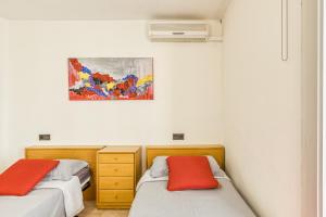 two beds in a room with a painting on the wall at Roses Sweet Home in Roses