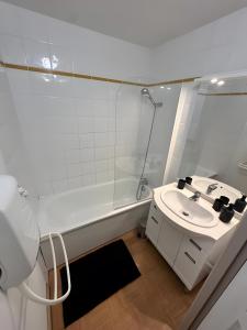 a white bathroom with a sink and a shower at Les evettes 4-6 couchages in Flumet