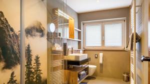 a bathroom with a sink and a toilet andwindows at Ferienhaus Unmüßig in Hinterzarten +21 photos