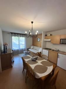 a kitchen and a living room with a table in a room at Les evettes 4-6 couchages in Flumet
