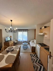 a kitchen and living room with a table and a dining room at Les evettes 4-6 couchages in Flumet +7 photos