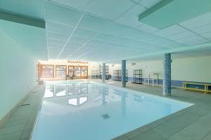 a large swimming pool with blue lighting in a building at Les evettes 4-6 couchages in Flumet