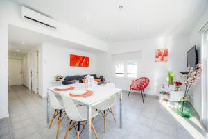 a dining room and living room with a white table and chairs at Can Picafort Sea Breeze in Can Picafort