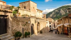 an alley in a town with a mountain in the background at Can Picafort Sea Breeze in Can Picafort