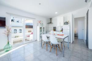 a kitchen and dining room with a table and chairs at Can Picafort Sea Breeze in Can Picafort +34 photos