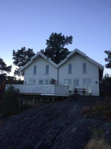a large white house sitting on top of a hill at Sponavik Camping in Stord