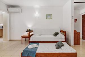 a bedroom with two beds and a desk and a table at Casa Ferrão in Armação de Pêra