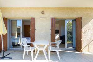 a table and chairs on the patio of a house at Les Mimosas - Appartement 05 in Cazaubon
