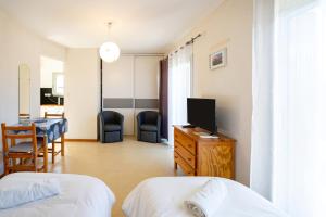 a hotel room with two beds and a television at Les Mimosas - Appartement 05 in Cazaubon