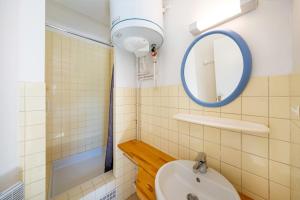a bathroom with a sink and a mirror at Les Mimosas - Appartement 05 in Cazaubon +12 photos