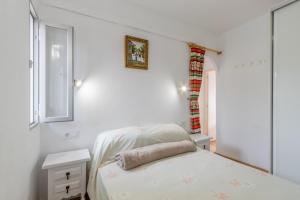 a white room with a bed and a window at Retirosol Bungalow in Denia