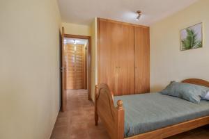 a bedroom with a bed and a wooden cabinet at Palm Serenity in Playa Paraiso +23 photos