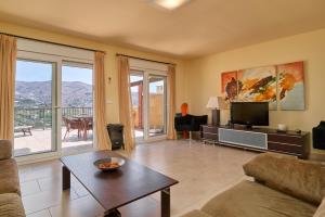 a living room with a couch and a tv at Casa Fuentes 2 B2 in Almuñécar