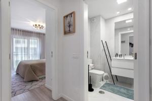 a white bathroom with a sink and a bed at Coral Beach Oasis in Figueira da Foz +16 photos